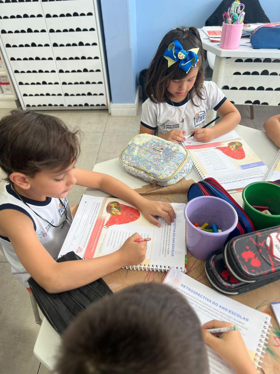 Crianças fazendo atividade em grupo com apostila no Colégio Futura Infantil em Jundiaí-SP