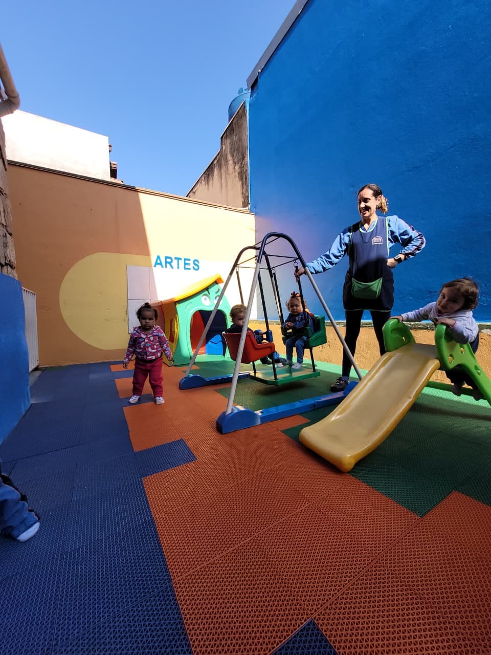 Crianças brincando no parquinho com escorregador e balanço no Colégio Infantil Futura.