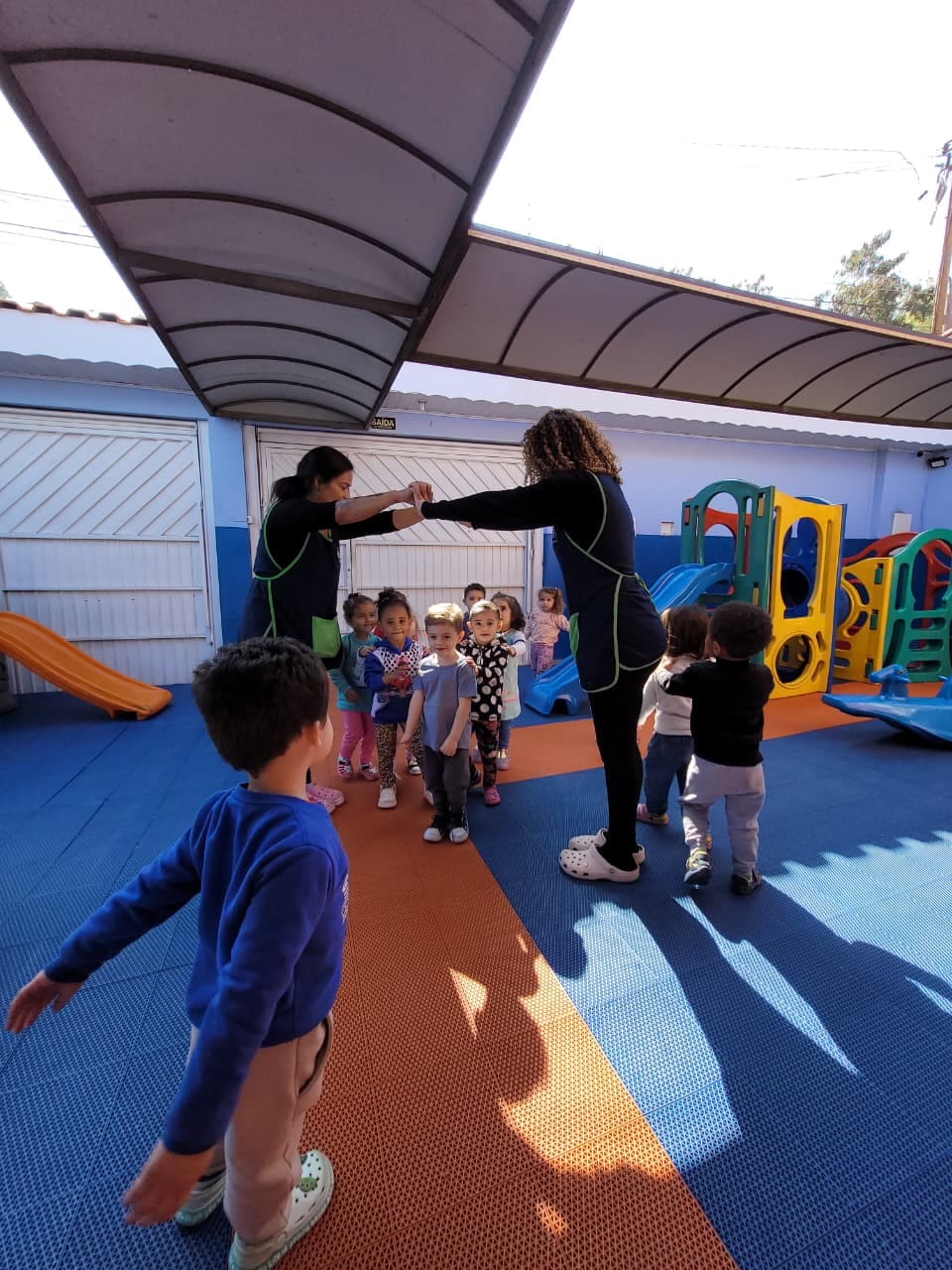 Crianças participando de atividade em grupo no parquinho do Colégio Futura Infantil em Jundiaí-SP com professores