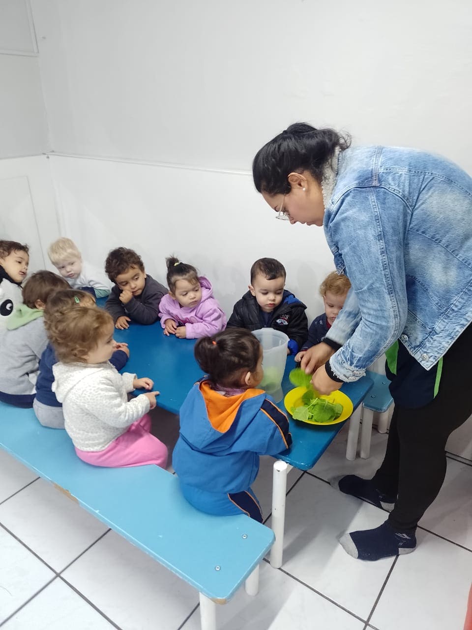 Professora apresenta alimentos saudáveis para crianças em atividade no Colégio Infantil Futura.
