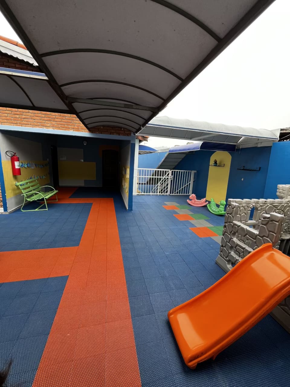 Parquinho do Colégio Futura Infantil em Jundiaí com escorregador e brinquedos coloridos em área protegida.