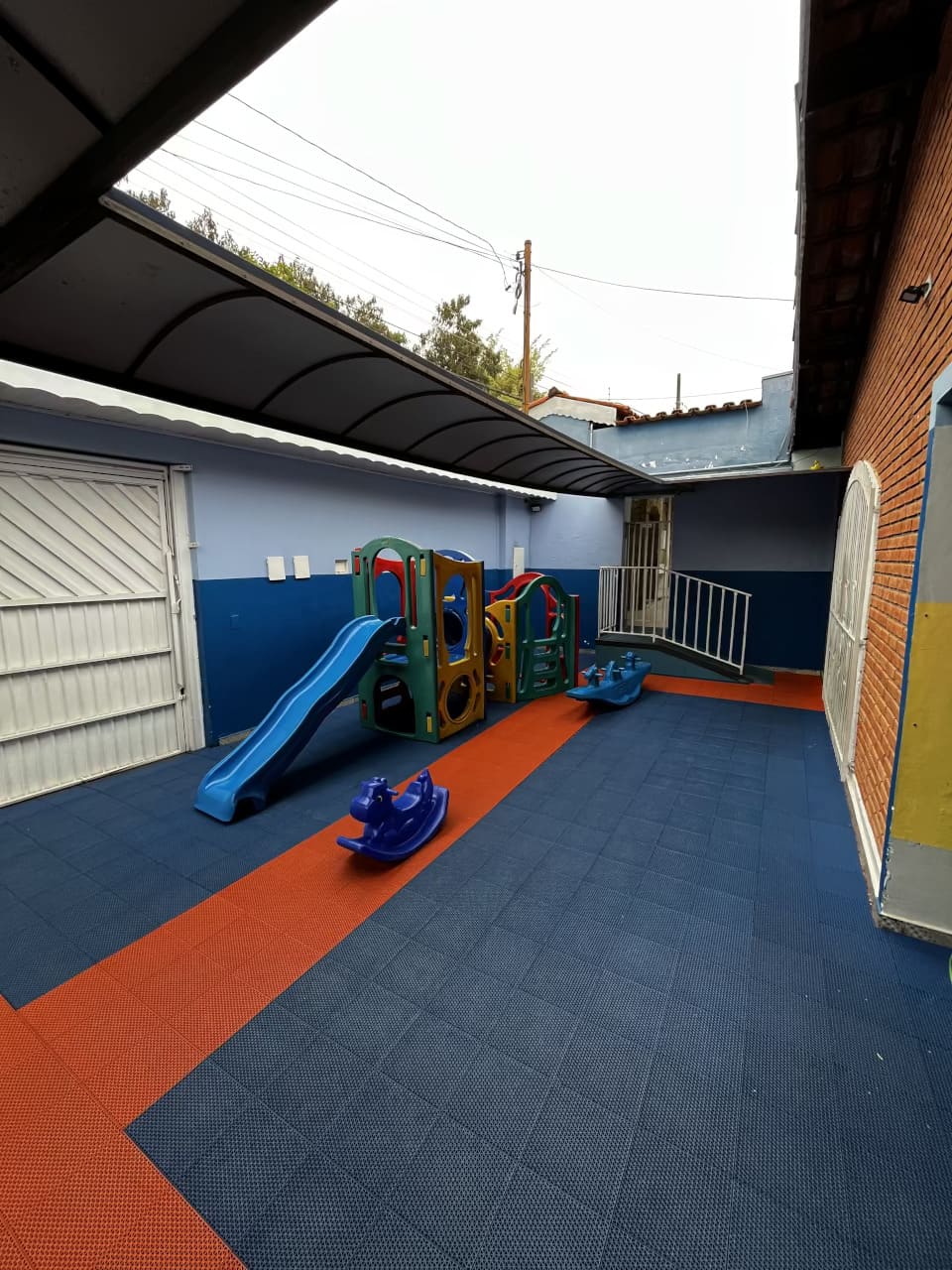 Parquinho do Colégio Futura Infantil em Jundiaí com escorregador e brinquedos coloridos em área protegida.