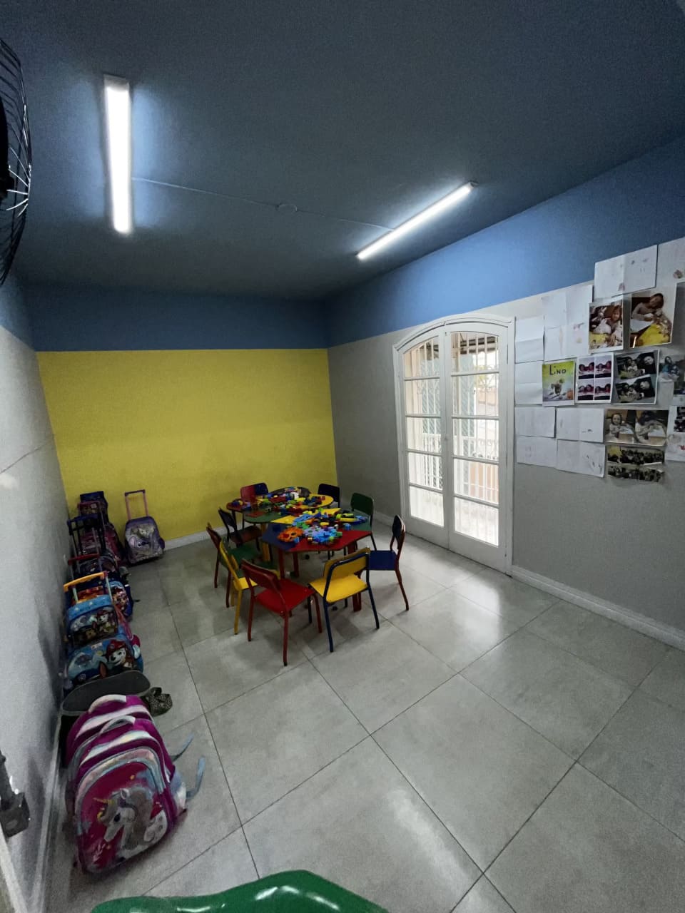 Sala de aula do Colégio Futura Infantil em Jundiaí com mesas coloridas, brinquedos educativos e mochilas organizadas.