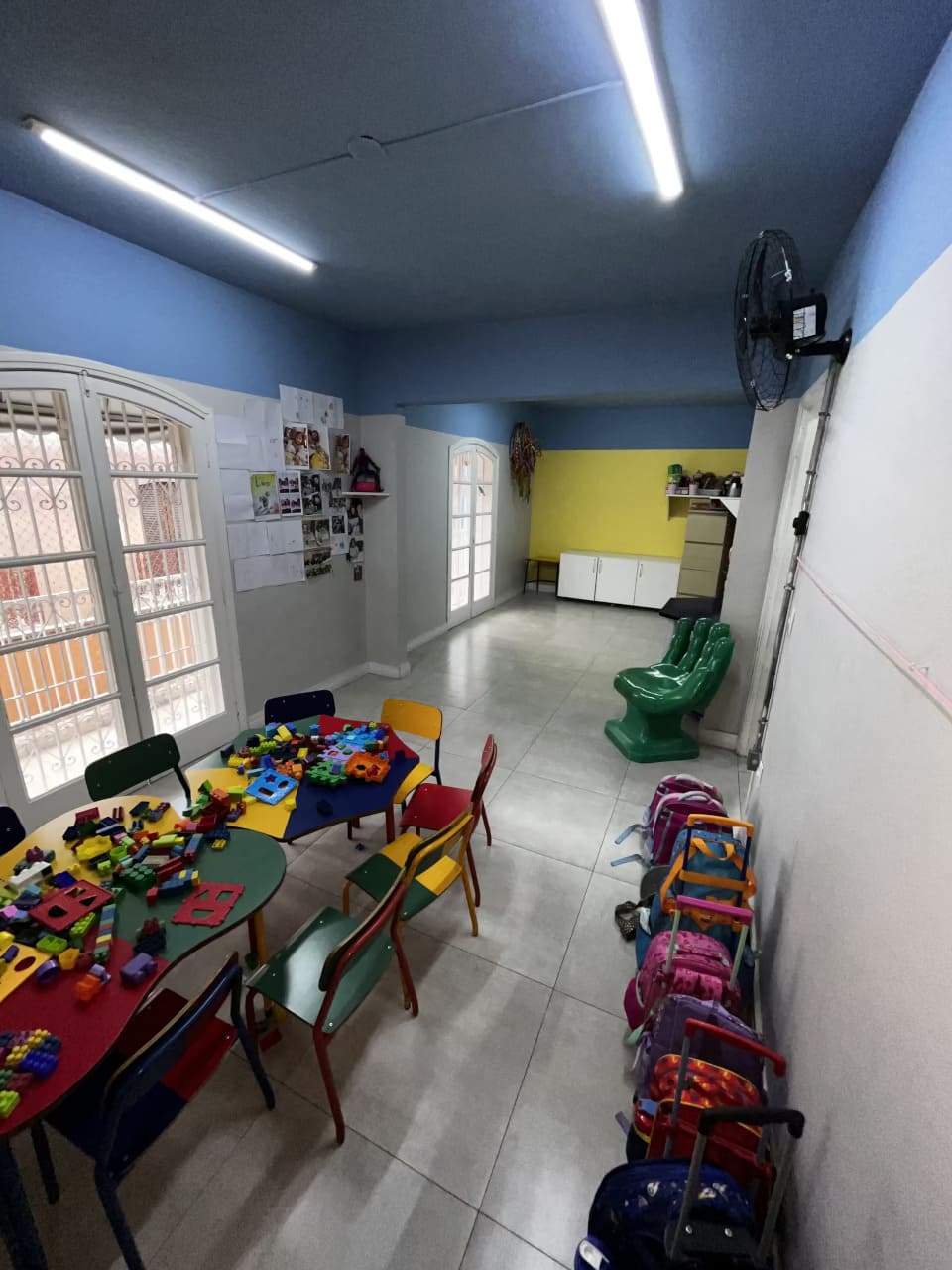 Sala de aula do Colégio Futura Infantil em Jundiaí com mesas coloridas, brinquedos educativos e mochilas organizadas.