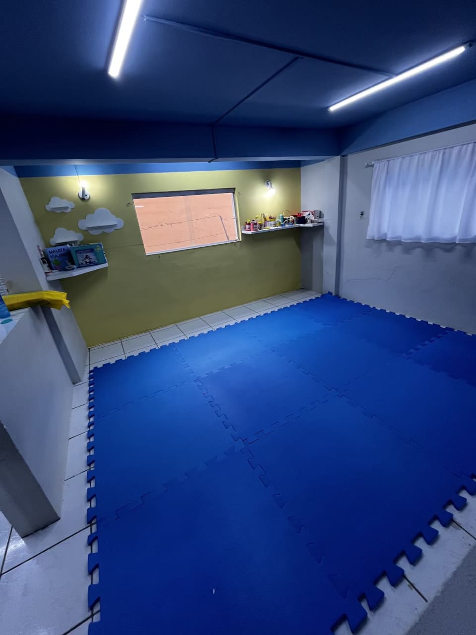 Sala de atividades do Colégio Futura Infantil com tatame azul e decoração lúdica.
