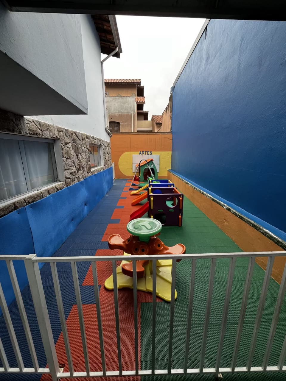 Espaço infantil do Colégio Futura em Jundiaí com balanços, escorregadores e piso emborrachado colorido.