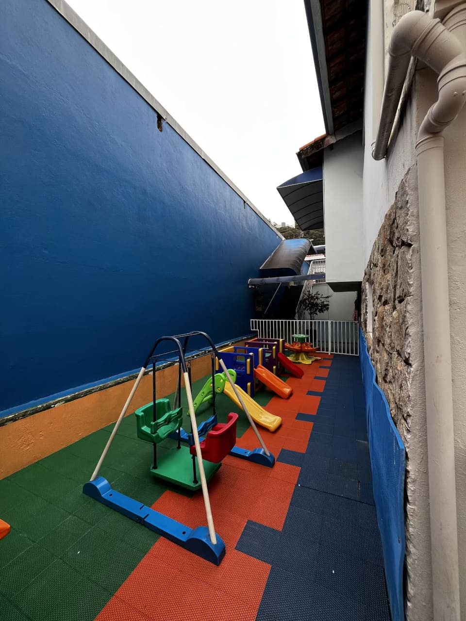Espaço infantil do Colégio Futura em Jundiaí com balanços, escorregadores e piso emborrachado colorido.
