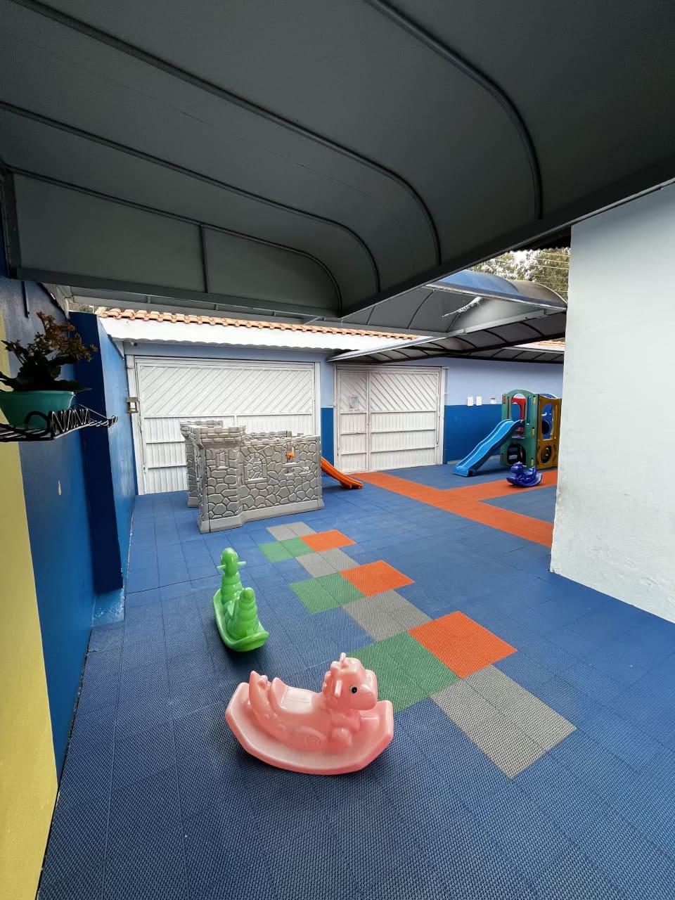 Área externa do Colégio Futura Infantil em Jundiaí com escorregador, castelinho de brinquedo e piso emborrachado.