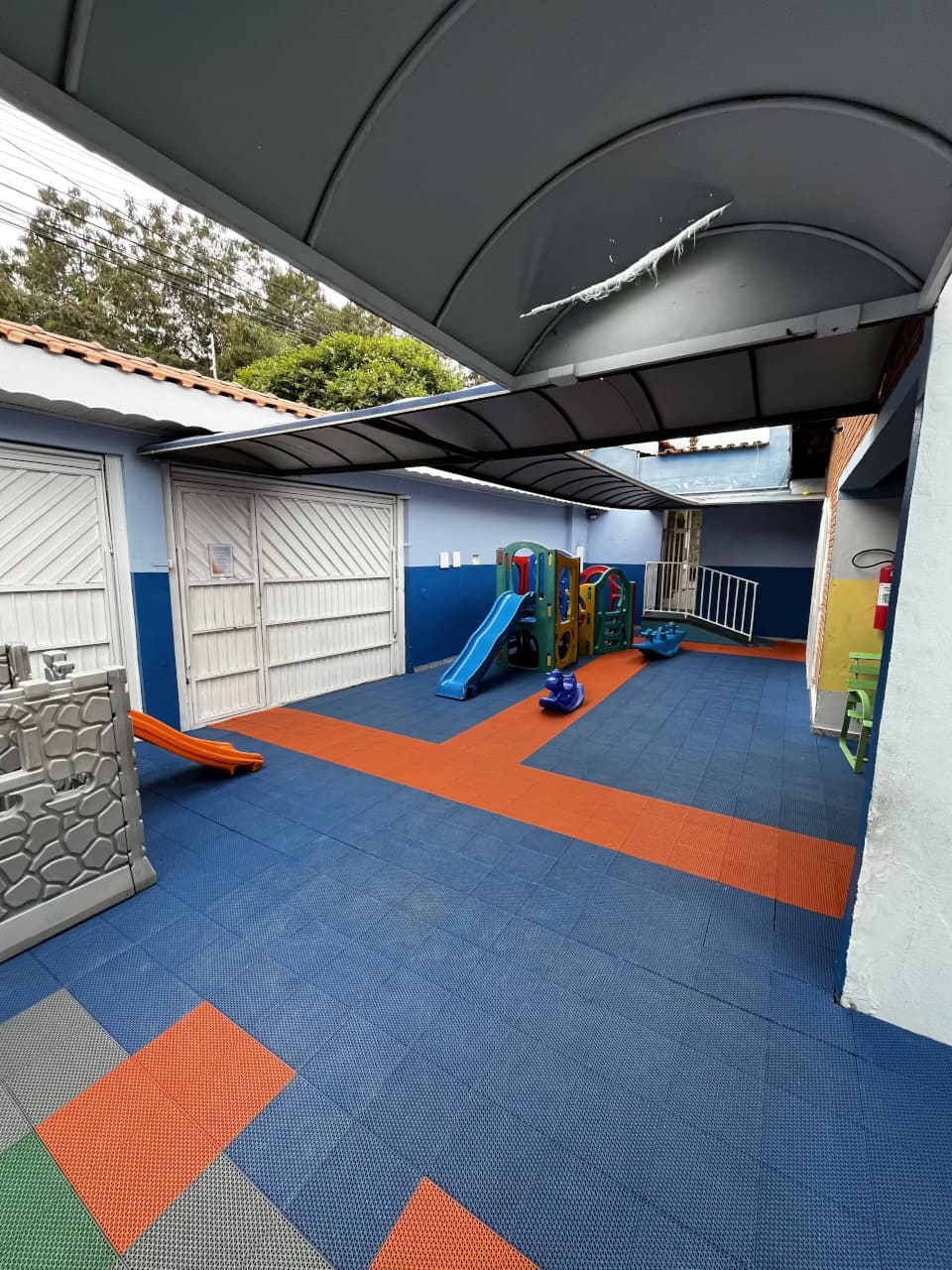Área externa do Colégio Futura Infantil em Jundiaí com escorregador, castelinho de brinquedo e piso emborrachado.