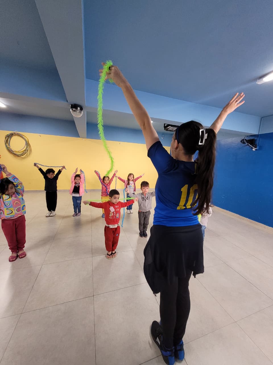 Professora de Arte e Movimento no Colégio Futura Infantil liderando uma atividade lúdica com crianças.