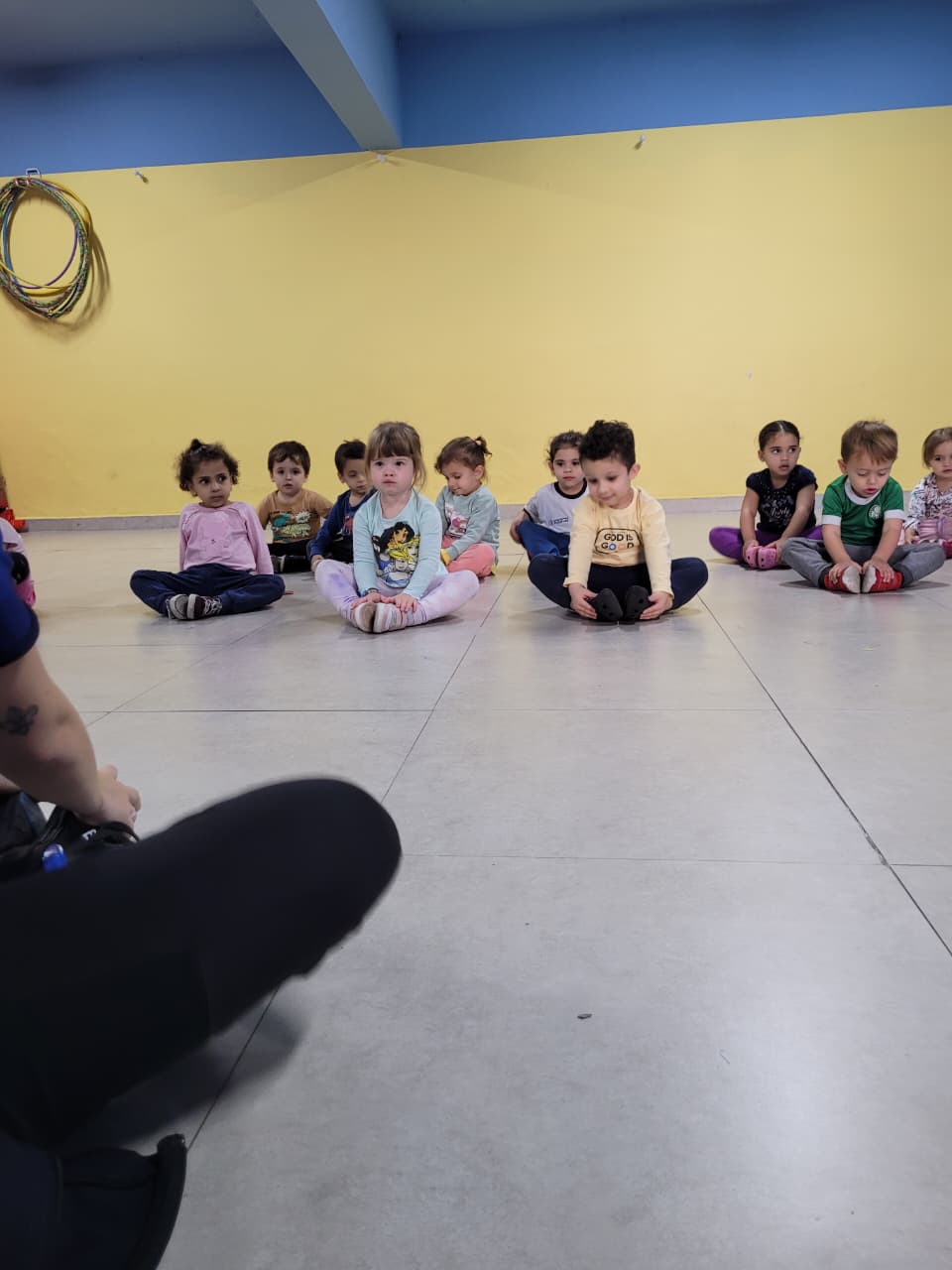 Professora e grupo de crianças sentadas no chão em aula de Arte e Movimento no Colégio Futura Infantil em Jundiaí.