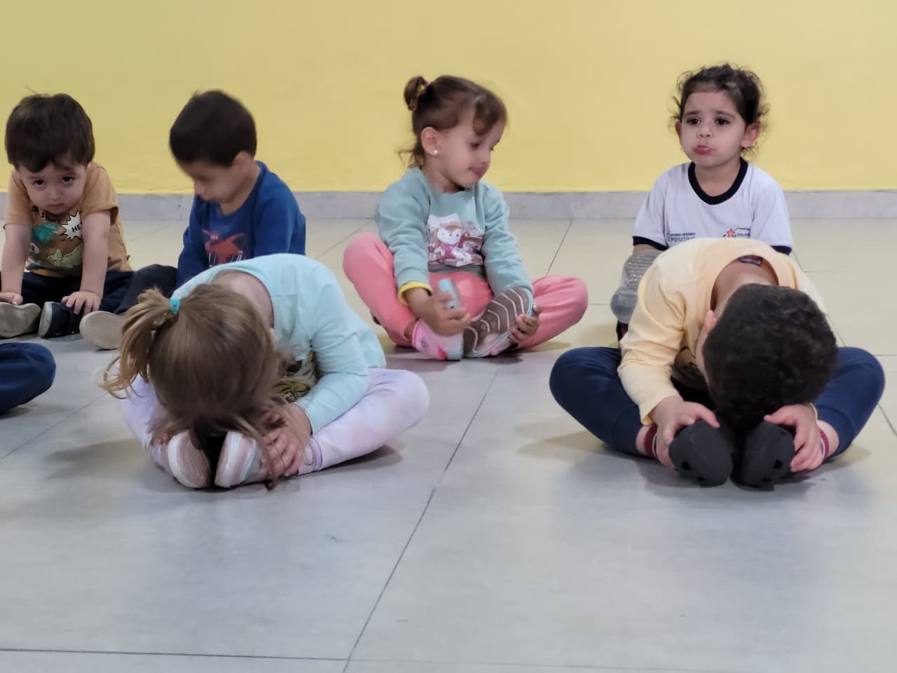 Crianças do Colégio Futura Infantil fazendo alongamento na aula de Arte e Movimento em Jundiaí.