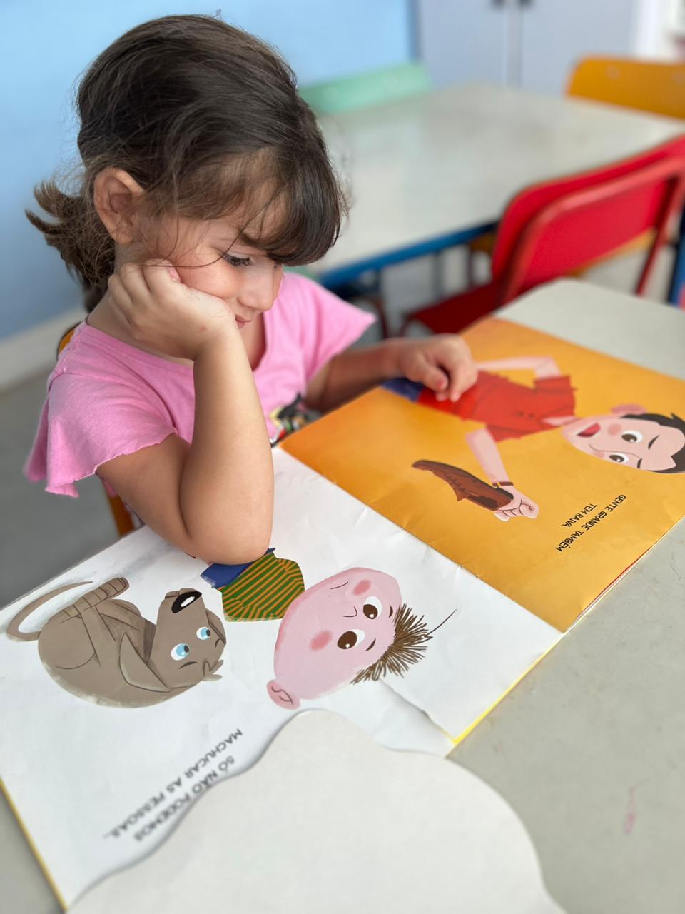 Criança do Colégio Futura Infantil lendo livro ilustrado no Projeto Pequenos Pensadores – Grandes Valores.