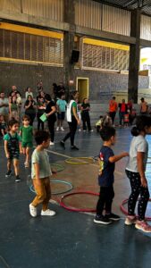 Crianças brincando com bambolês na quadra durante a 6ª Festa da Família do Colégio Futura 2025.