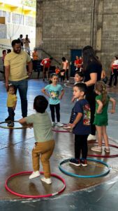 Crianças brincando com bambolês na quadra durante a 6ª Festa da Família do Colégio Futura 2025.