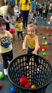 Crianças brincando com bolas coloridas em atividade recreativa na 6ª Festa da Família do Colégio Futura 2025.