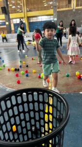 Crianças brincando com bolas coloridas em atividade recreativa na 6ª Festa da Família do Colégio Futura 2025.