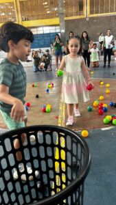 Crianças brincando com bolas coloridas em atividade recreativa na 6ª Festa da Família do Colégio Futura 2025.