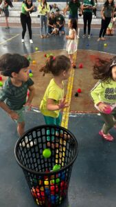 Crianças brincando com bolas coloridas em atividade recreativa na 6ª Festa da Família do Colégio Futura 2025.