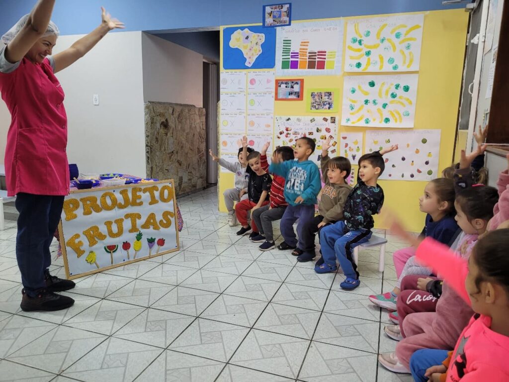 Nutricionista Ana Paula Silva fazendo atividade lúdica sobre Projeto Frutas com crianças do Colégio Futura Jundiaí.