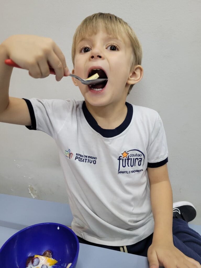 Criança do Colégio Futura Jundiaí degustando frutas em vivência com nutricionista e aprendendo sobre alimentação saudável.