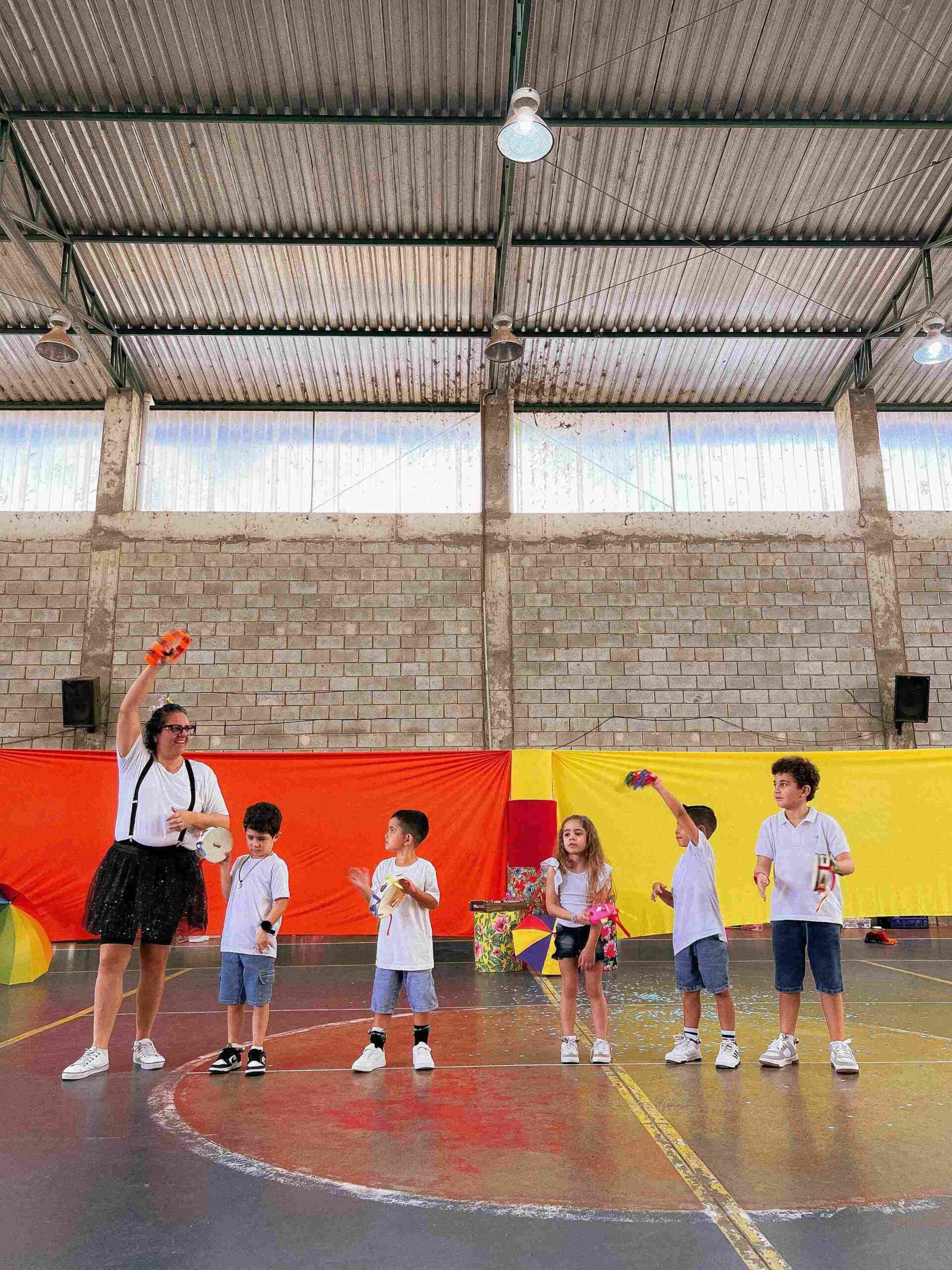 Professora e alunos com pandeiros na apresentação musical do Sarau 2025 no Colégio Futura Infantil Jundiaí.
