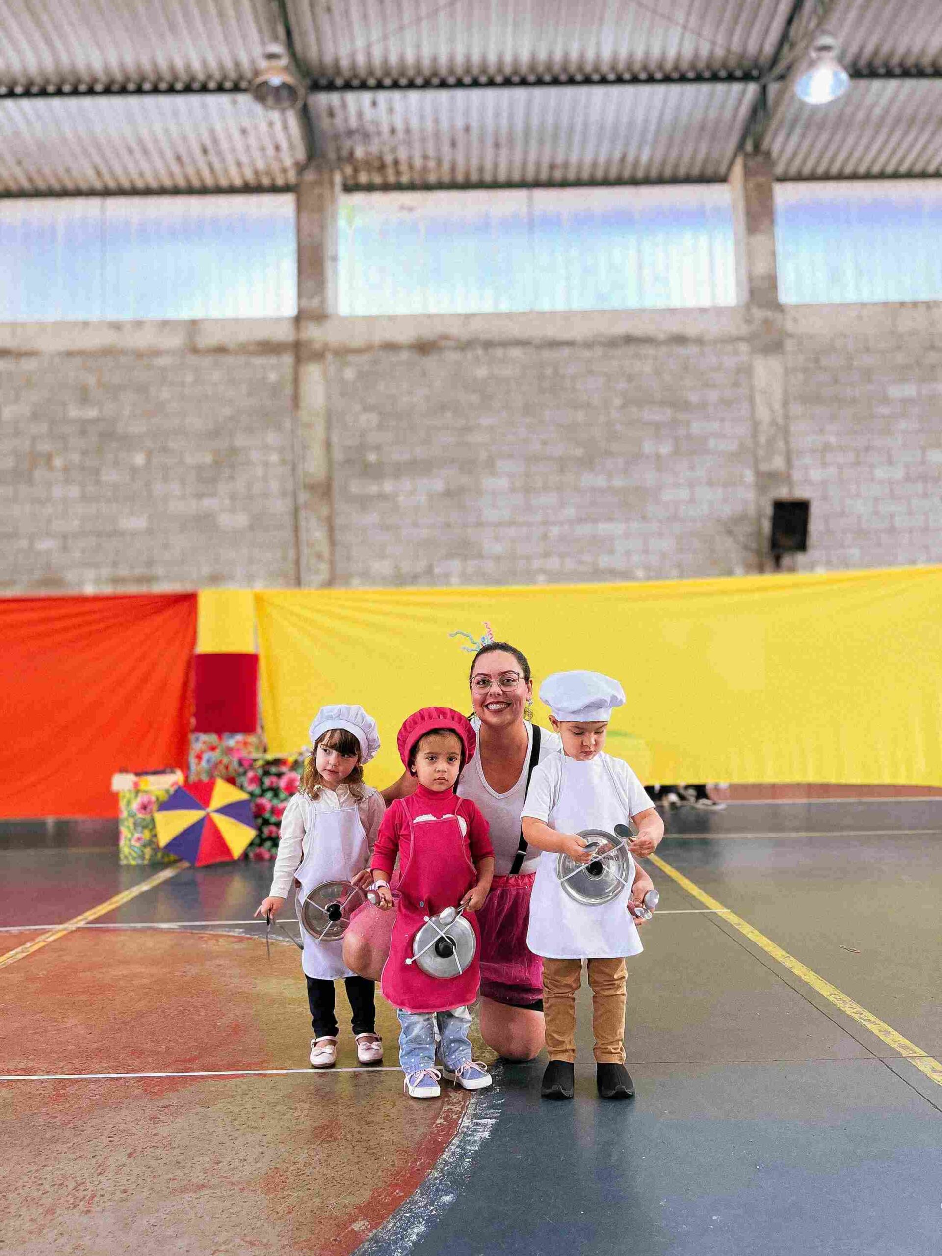 Crianças vestidas de cozinheiros com panelas e professora no Sarau 2025 do Colégio Futura Infantil em Jundiaí.