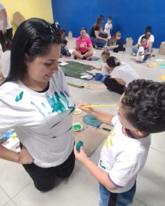 Criança pinta camiseta de adulto no evento Entre Cores e Afetos do Colégio Futura Infantil em Jundiaí SP