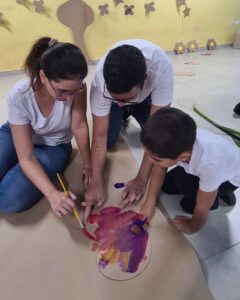 Criança e adultos colaboram em pintura colorida no evento Entre Cores e Afetos do Colégio Futura Infantil em Jundiaí SP