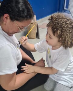 Criança pinta rosto de adulto no evento Entre Cores e Afetos do Colégio Futura Infantil em Jundiaí SP