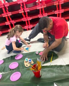 Criança e adulto pintam recortes de borboleta no evento Entre Cores e Afetos do Colégio Futura Infantil em Jundiaí SP
