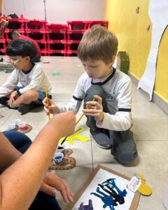 Criança participa de atividade de pintura em cartolina no evento Entre Cores e Afetos do Colégio Futura Infantil em Jundiaí SP