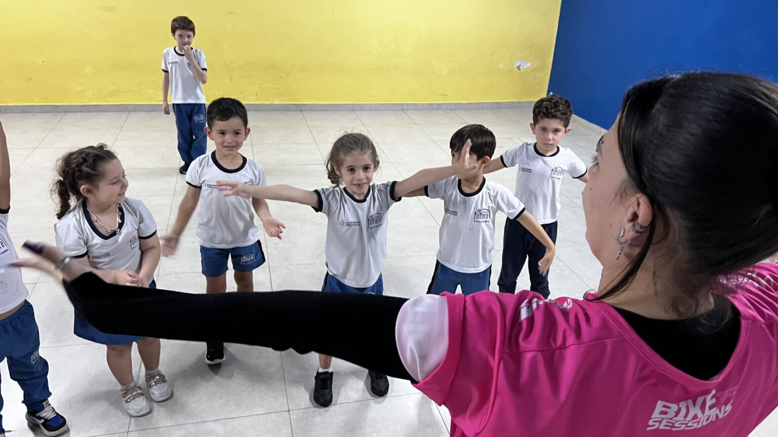 Crianças estendendo os braços em aula de dança no Colégio Futura Infantil em Jundiaí-SP.